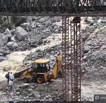 जेसीबी मशीन से सहारे कूपड़ा खड्ड को पार कर रहे ग्रामीण व स्कूली बच्चे