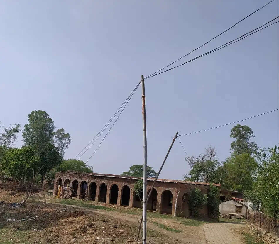 बांस-बल्लियों के सहारे जल रही रोशनी, चार माह से सड़क किनारे पड़े हैं बिजली के पोल